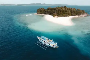 Seatours expedition boat anchored at a Linapacan island on the Coron to El Nido 3D2N route