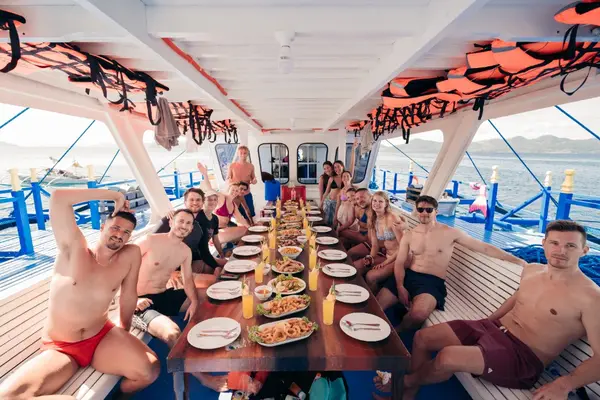 Travelers enjoying grilled seafood buffet lunch on deck aboard the Seatours 3D2N expedition boat on a private 3D2N Palawan charter
