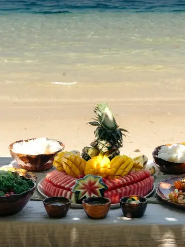 Private island lunch on white sand with crystal-clear Bacuit Bay water — Seatours El Nido private charter